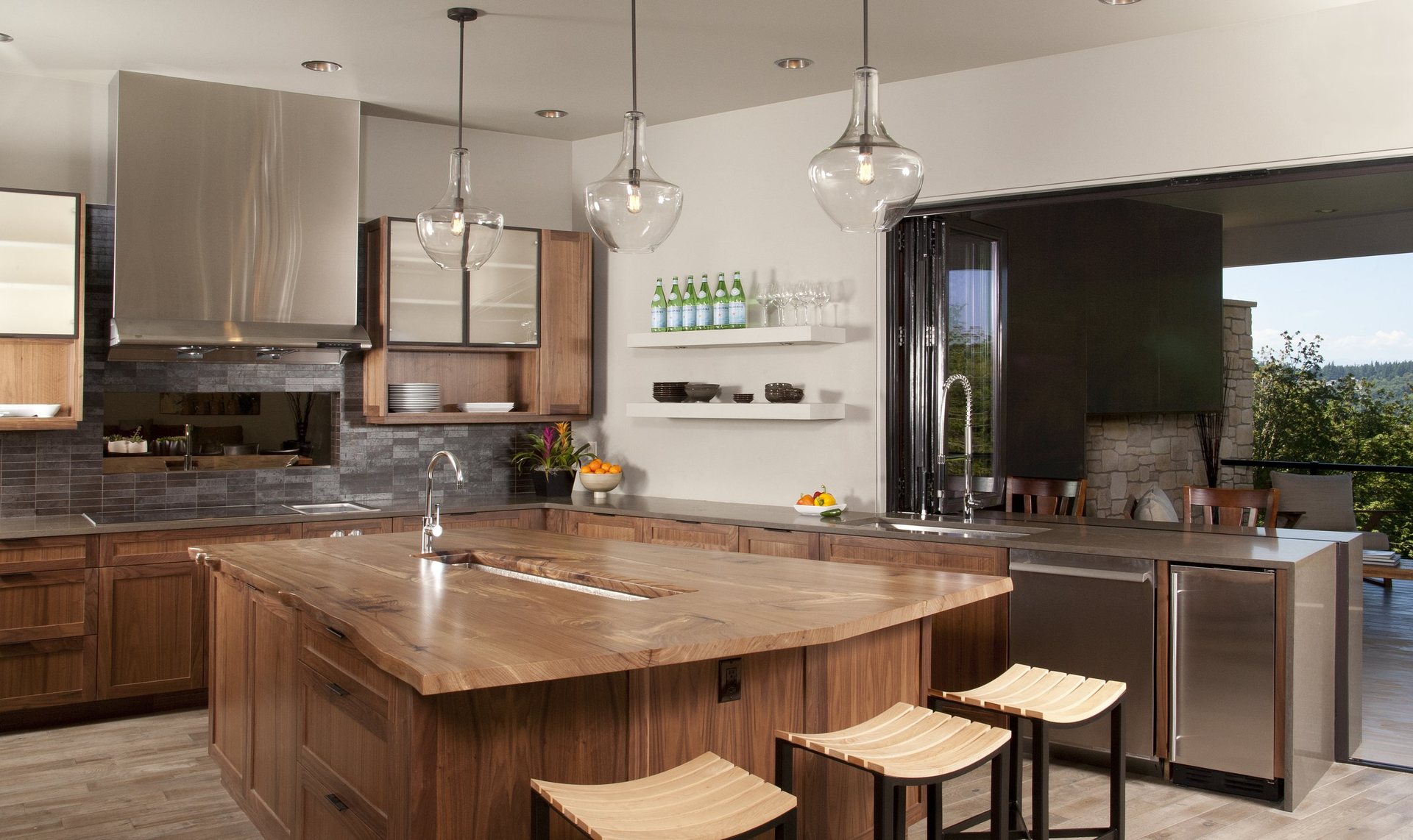 Walnut kitchen with a live-edge walnut island, slate backsplash and hand-blown glass pendants